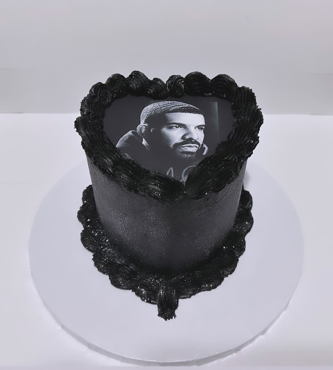 Black heart-shaped cake featuring an edible photo of Drake, ideal for personalized and themed celebrations.